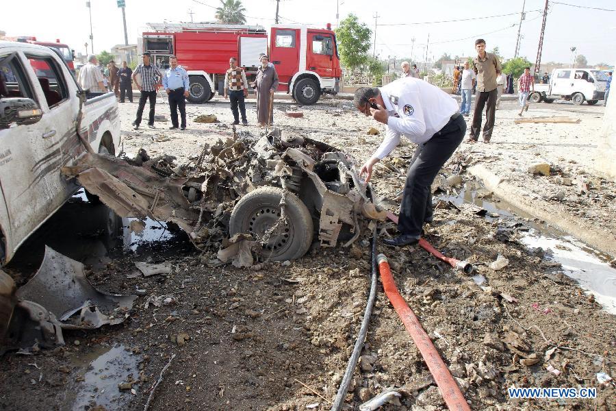 Rescuers look over the site where a car bomb attack happened in Kirkuk, a northern city of Iraq, April 15, 2013. At least 16 people died and 100 people injured in several bomb attacks that happend in different places of Iraq on Monday. (Xinhua/Dena Assad) 