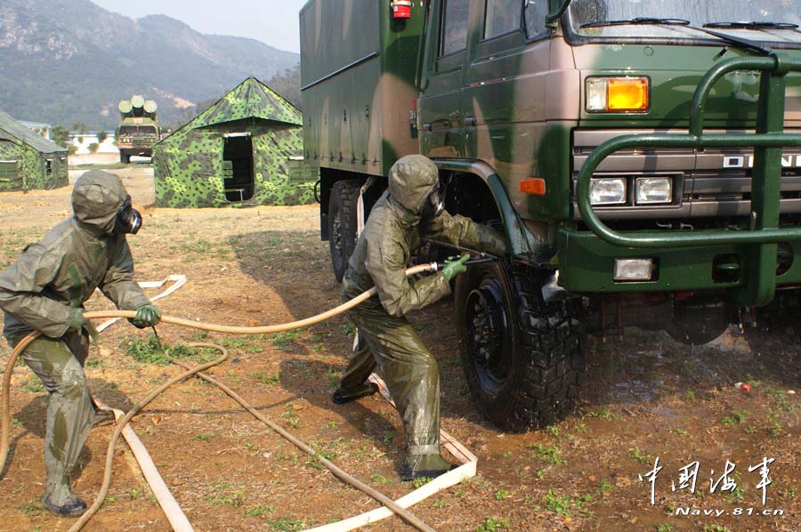 A shore-based mobile anti-ship-missile regiment under the South China Sea Fleet of the Navy of the Chinese People's Liberation Army (PLA) organized a NBC (nuclear, biological and chemical) defense drill against actual-combat background on April 7, 2013. The picture shows the officers and men of the regiment are carrying out decontamination and detection of chemical agents in the infected "toxic" areas. (China Military Online/Sheng Yuehua, Zhao Changhong and Zheng Can)