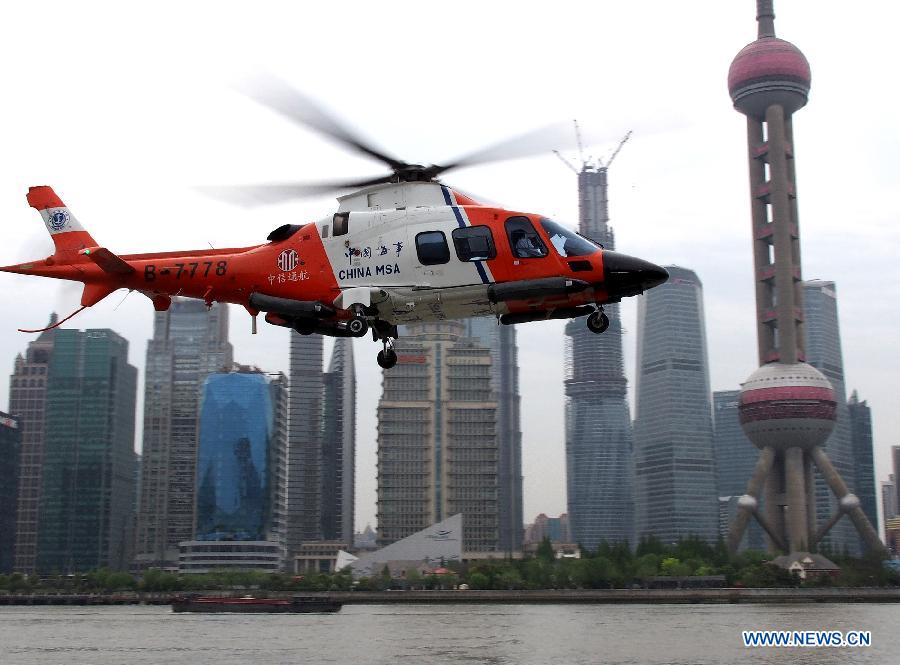 A rescue helicopter of patrol vessel Haixun 01 (not in photo) flies over the Huangpu River in Shanghai, east China, April 16, 2013. Haixun 01, officially delivered and put into service Tuesday and managed by the Shanghai Maritime Bureau, is China's largest and most advanced patrol vessel. The 5,418-tonnage Haixun01 is 128.6 meters in length and has a maximum sailing distance of 10,000 nautical miles (18,520 km) without refueling. It will carry out missions regarding maritime inspection, safety monitoring, rescue and oil spill detection and handling. (Xinhua/Chen Fei) 