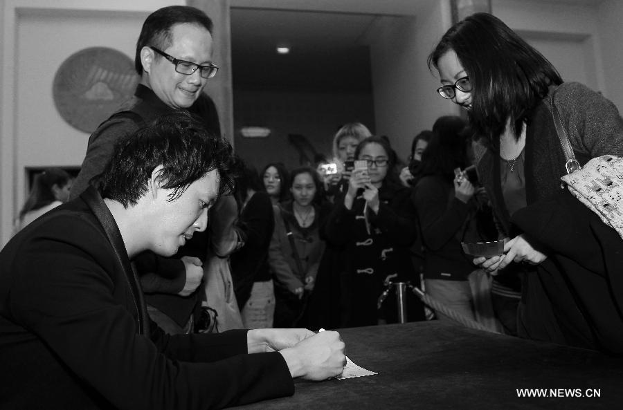 Chinese pianist Li Yundi (L) signs for fans after his concert in Paris, France, April 15, 2013. Famous Chinese pianist Li Yundi was on his European tour started on March 18 ending in Berlin on May 14 en route Frankfurt, Munich, Paris, London, Liverpool, Moscow, Strasbourg, among others. Born in southwest China's Chongqing Municipality, Li was the youngest pianist to win the International Frederic Chopin Piano Competition in 2000, at the age of 18. (Xinhua/Gao Jing) 