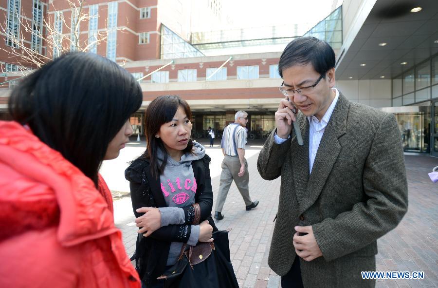 Chinese Vice Counselor-General Zhong Ruiming (R) of the Chinese Consulate General in New York helps local Chinese people contact with their relatives and friends at the Boston Medical Center in Boston, the United States, April 16, 2013. Chinese student Zhou Danling, who was injured during the Boston marathon blasts, turned into better condition from critical one after receiving two surgeries. (Xinhua/Wang Lei) 