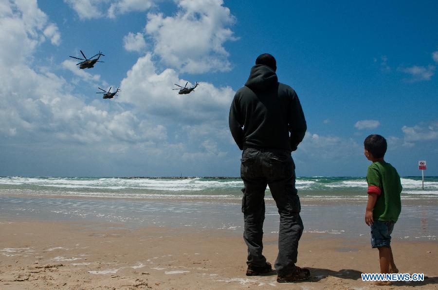 People watch the performance of aerobatic flights by Israeli aircrafts above the Mediterranean Sea near Tel Aviv during a celebration for Israel's Independence Day, April 16, 2013. Beginning at sundown Monday and ending at sundown on Tuesday, Israel celebrated its Independence Day marking the country's 65th anniversary. (Xinhua/Han Chong) 