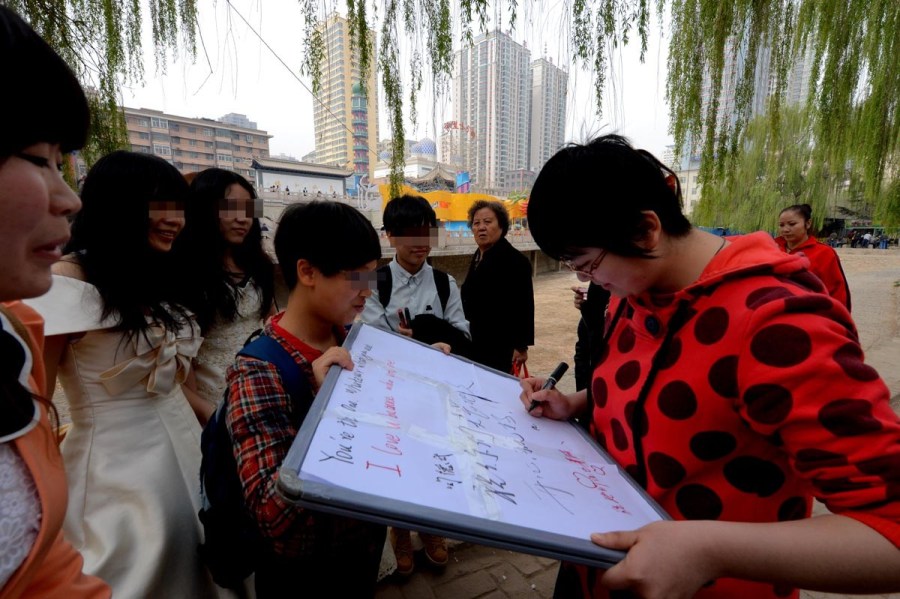 Lesbian lovers hold a wedding ceremony in a park of Lanzhou on April 15, 2012. They held a sign reading "Woman loves woman, lesbians need bless" to call for tolerance of homosexual marriage. 