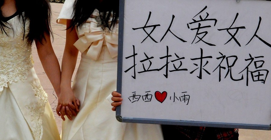 Lesbian lovers hold a wedding ceremony in a park of Lanzhou on April 15, 2012. They held a sign reading "Woman loves woman, lesbians need bless" to call for tolerance of homosexual marriage. 