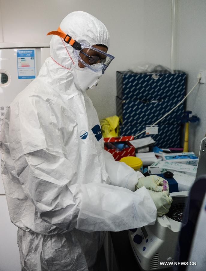 A researcher in protective suit isolates nucleic acid from samples of a suspected case of the H7N9 avian influenza virus at the provincial center for disease control and prevention in Hangzhou, capital of east China's Zhejiang Province, April 17, 2013. An emergent testing team on 24-hour stand-by was set up in the center after the recent spread of the H7N9 virus. Infections within the province will be officially confirmed by the center. (Xinhua/Xu Yu)