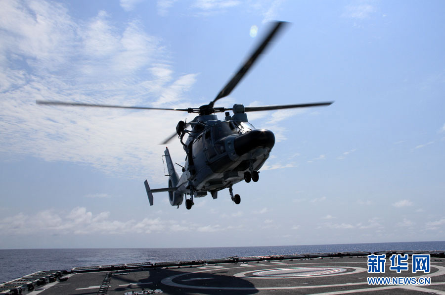 A ship-borne helicopter on the "Lanzhou" warship is flying to the "Hengshui" warship which simulates a merchant ship. (Xinhua/Yang Lei)