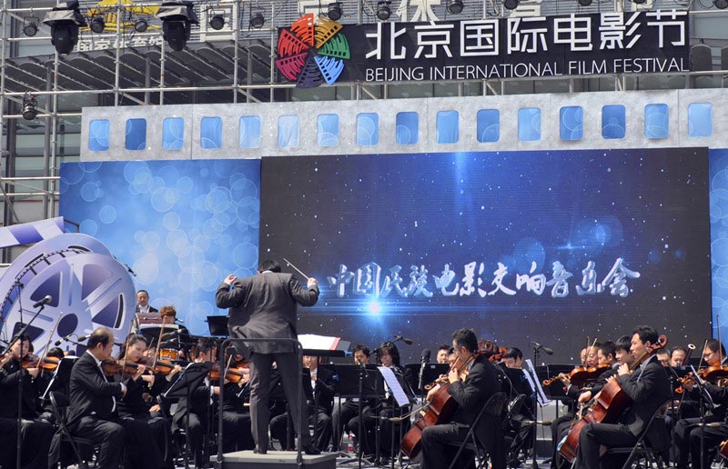 An orchestra performs at China's ethnic minority film score concert at the opening ceremony of "The Best in Wo-Film Carnival," in Beijing, April 16, 2013. The carnival is open to the public from April 16-23 during the 3rd Beijing International Film Festival. The carnival is a large-scale public cultural activity integrating film cultural entertainment and interactive experiences, as well as tourism and leisure. (China.org.cn)
