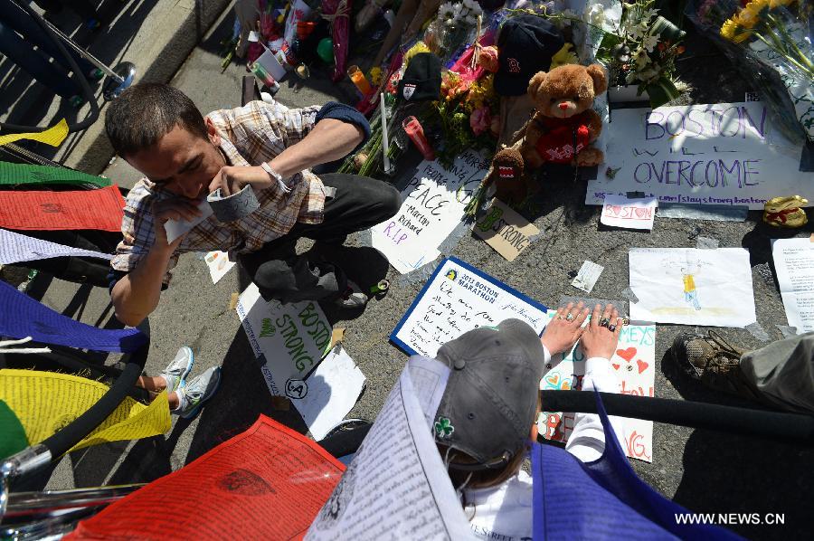 A citizen offers flowers for the victims in Boston Marathon blasts in Boston, the United States, April 17, 2013. (Xinhua/Wang Lei) 