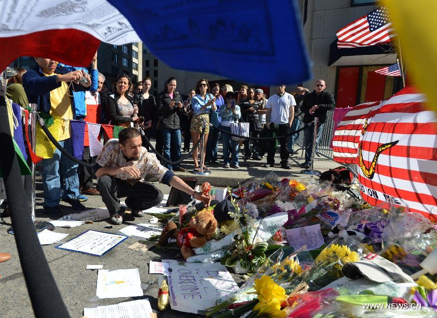 A citizen offers flowers for the victims in Boston Marathon blasts in Boston, the United States, April 17, 2013. (Xinhua/Wang Lei) 