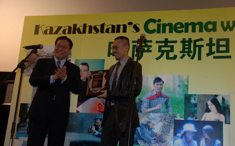 Zhang Pimin (L), Deputy Secretary of the State General Administration of Press, Publication, Radio, Film and Television of PRC, presents a certificate to Chinese actor Wang Xuebing (R), who is selected as the ambassador of the Kazakhstan's Cinema Week on April 17, 2013. (PD Online/Deng Jie)
