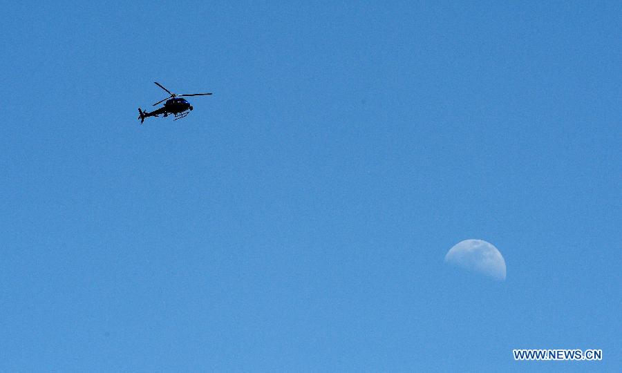 A helicopter hovers over the campus of the California State University Los Angeles (CSULA) in Los Angeles, April 18, 2013. The campus of the California State University Los Angeles (CSULA) is being evacuated Thursday due to a bomb threat. The CSULA announced the evacuation around noon, through loud speakers on the campus and Twitter, as a precaution, but did not provide additional information. Most of students and staff have been evacuated. (Xinhua/Yang Lei) 