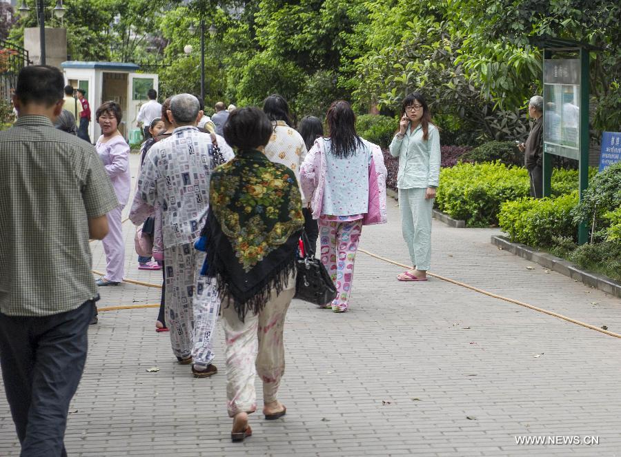 Citizens wearing pajamas gather outside their apartments to avoid aftershocks of an earthquake, in Chongqing, southwest China, April 20, 2013. A 7.0-magnitude earthquake hit Lushan County of neighboring Sichuan Province, also in southwest China, at 8:02 a.m. Beijing Time (0002 GMT) on Saturday, according to the China Earthquake Networks Center (CENC). The epicenter, with a depth of 13 kilometers, was monitored at 30.3 degrees north latitude and 103.0 degrees east longitude. Residents in Chongqing also felt the earthquake. (Xinhua/Chen Cheng)