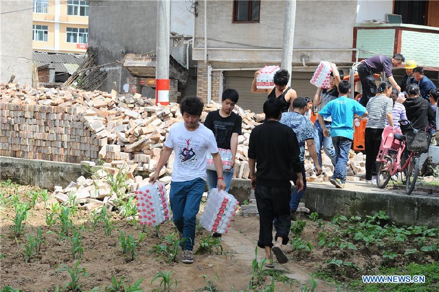 Local residents get bottled water in quake-hit Lushan County, Ya'an City, southwest China's Sichuan Province, April 20, 2013. (Xinhua/Jin Xiaoming)