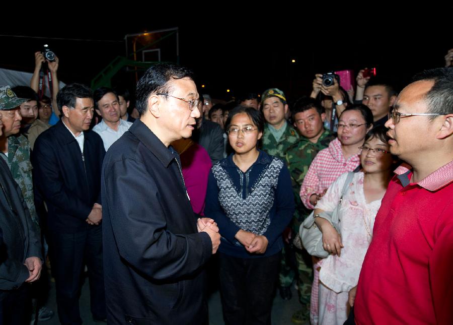 Chinese Premier Li Keqiang (L, front), also a member of the Standing Committee of the Political Bureau of the Communist Party of China Central Committee, visits quake-affected people at a relocation site in a middle school of the quake-hit Lushan County, southwest China's Sichuan Province, April 20, 2013. Li Keqiang arrived in Sichuan Saturday afternoon to deploy quake relief work. (Xinhua/Huang Jingwen)