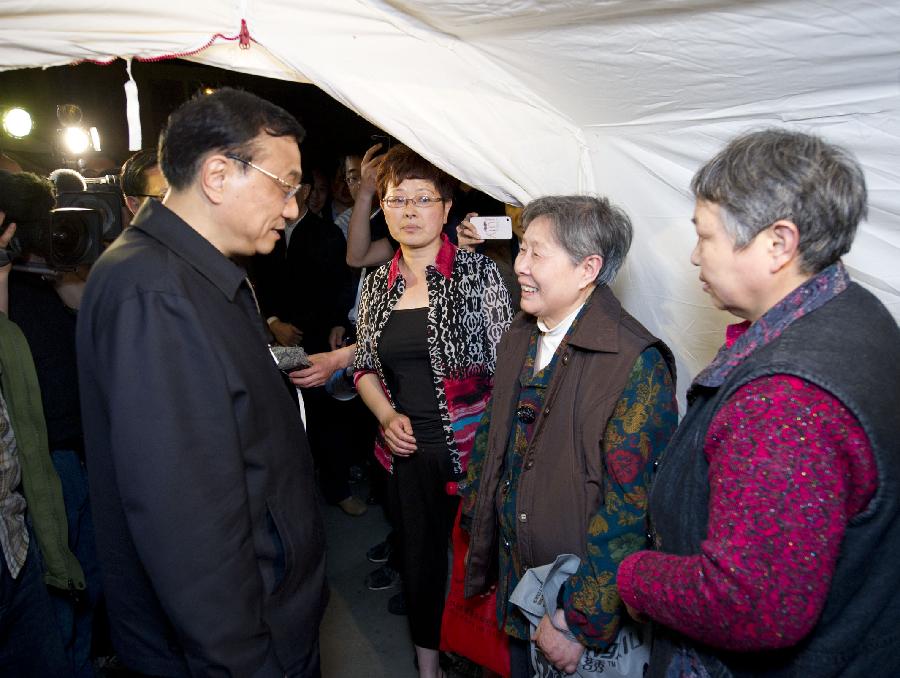 Chinese Premier Li Keqiang (L), also a member of the Standing Committee of the Political Bureau of the Communist Party of China Central Committee, visits quake-affected people at a relocation site in a middle school of the quake-hit Lushan County, Southwest China's Sichuan Province, April 20, 2013. Li Keqiang arrived in Sichuan Saturday afternoon to deploy quake relief work. (Xinhua/Huang Jingwen)