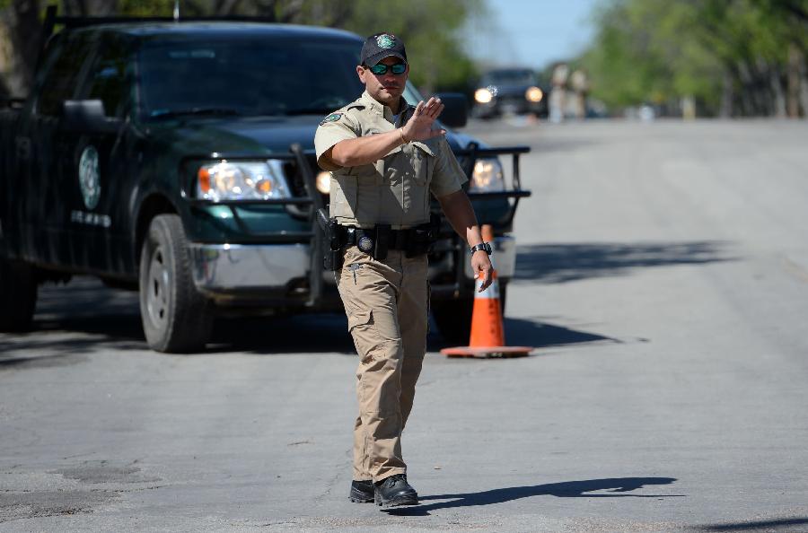 A policeman cordons off a road leading to the fertilizer plant in West, Texas, the United States, April 20, 2013. The Authorities of the city of West, the U.S. state of Texas, on Saturday declared to impose curfew while allowing some of the evacuated residents to return home in the afternoon, more than two days after a powerful explosion at a local fertilizer plant that almost razed the town. (Xinhua/Wang Lei) 