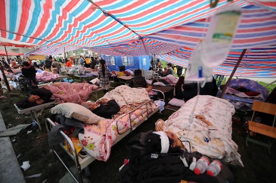 Injured people receive medical treatment in Lingguan Town of Baoxing County in Ya'an City, southwest China's Sichuan Province, April 21, 2013. A 7.0-magnitude earthquake hit Lushan County of Sichuan Province on Saturday morning, leaving 26 people dead and 2,500 others injured, including 30 in critical condition, in neighboring Baoxing County, county chief Ma Jun said. (Xinhua/Xue Yubin)  