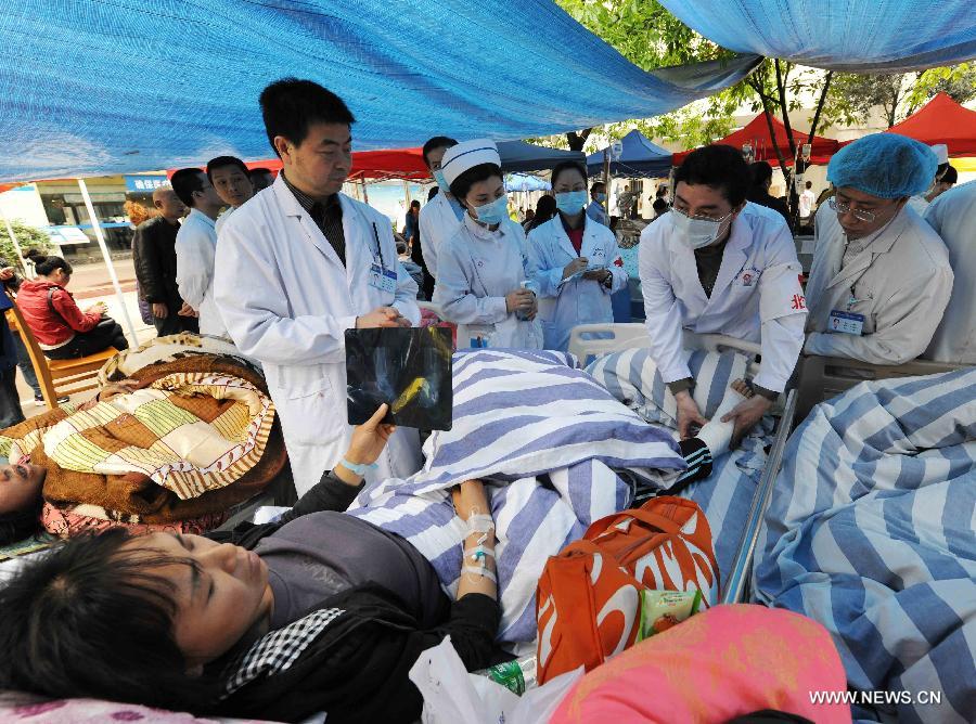 Doctors from Beijing, capital of China, give treatment to an injured person at the Second People's Hospital in Ya'an City, southwest China's Sichuan Province, April 21, 2013. A 7.0-magnitude earthquake hit Lushan County of Ya'an City in Sichuan Province on Saturday morning, leaving 180 people dead and 11,227 others injured so far. (Xinhua/Chen Shugen)