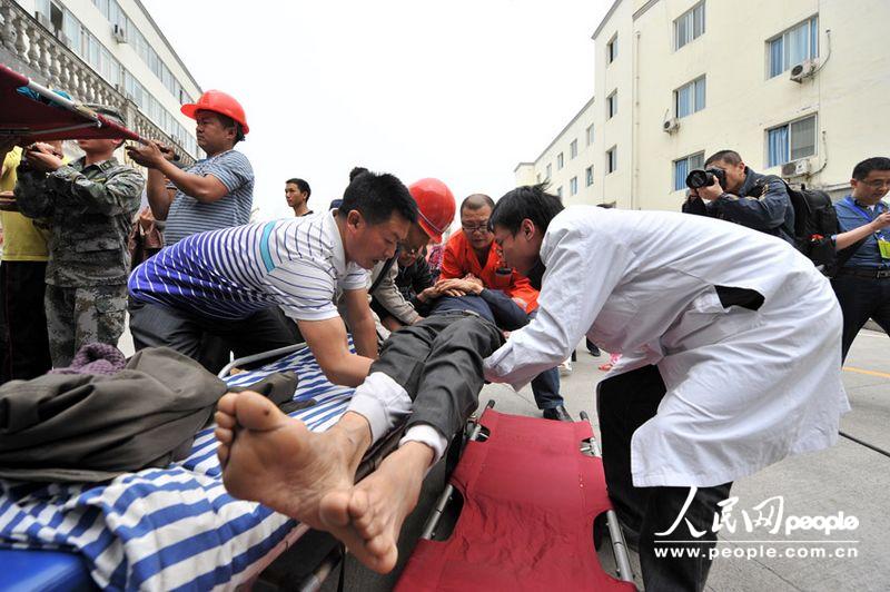 Doctors treat a wounded in the People's Hospital in Lushan, Sichuan province, April 21, 2013. More than 3,000 people had been sent here to get treatment as of 11:30 a.m. of April 21, 2013. (Weng Qiyu/People’s Daily Online)