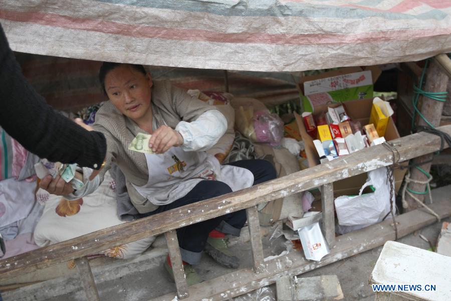 A convenience store owner runs her business in a makeshift tent in the quake-hit Baosheng Township, Lushan County, southwest China's Sichuan Province, April 21, 2013. Death toll has risen to 208 in the earthquake in Sichuan as of 5:00 p.m. Sunday, according to latest statistics gathered by local authorities. A 7.0-magnitude earthquake hit Lushan County at 8:02 a.m. Saturday Beijing time. (Xinhua/Zhang Xiaoli) 