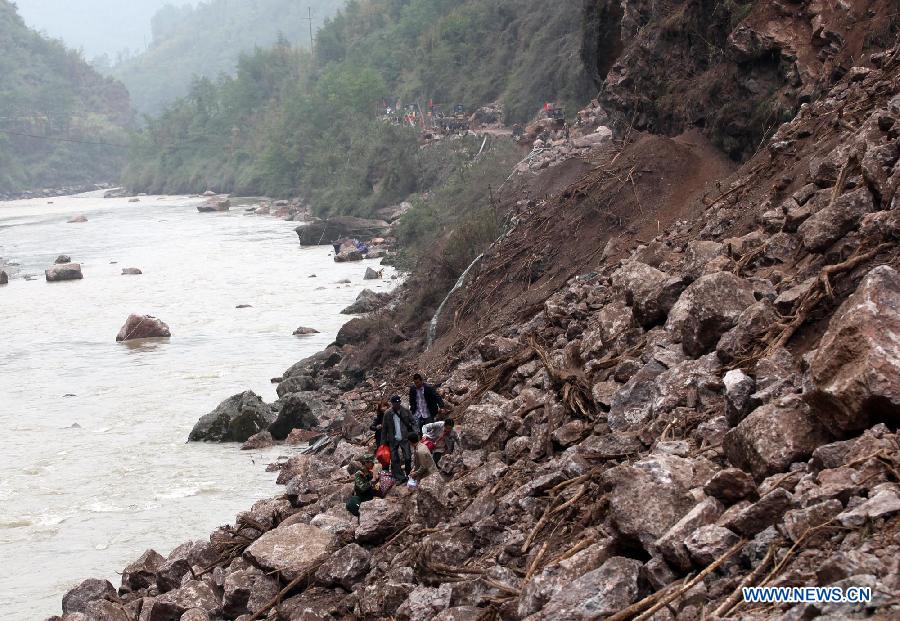 People walk on rocks fallen due to the landslide triggered by a strong quake in Baosheng Township, Lushan County, southwest China's Sichuan Province, April 21, 2013. Death toll has risen to 208 in the earthquake in Sichuan as of 5:00 p.m. Sunday, according to latest statistics gathered by local authorities. A 7.0-magnitude earthquake hit Lushan County at 8:02 a.m. Saturday Beijing time. (Xinhua/Zhang Xiaoli) 