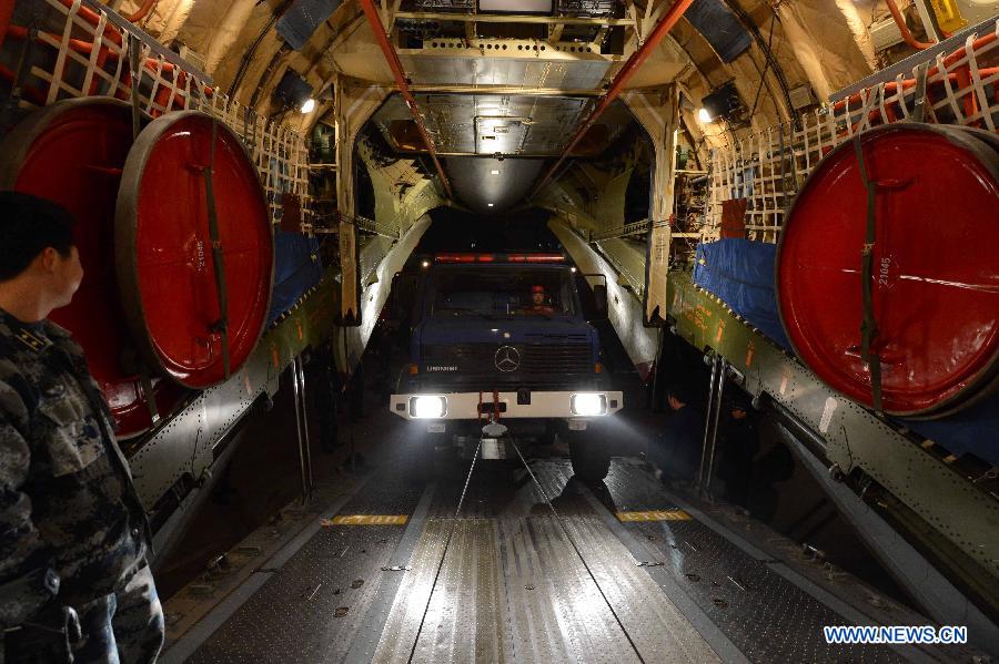 A rescue vehicle drives into an aircraft which is about to fly to the quake-hit Sichuan Province, at the Nanyuan Airport in Beijing, capital of China, April 21, 2013. A total of 140 rescuers and 12 sniffer dogs flew to the earthquake-hit Lushan County, southwest China's Sichuan Province, Saturday night to conduct rescue work. (Xinhua/Yu Hongchun)