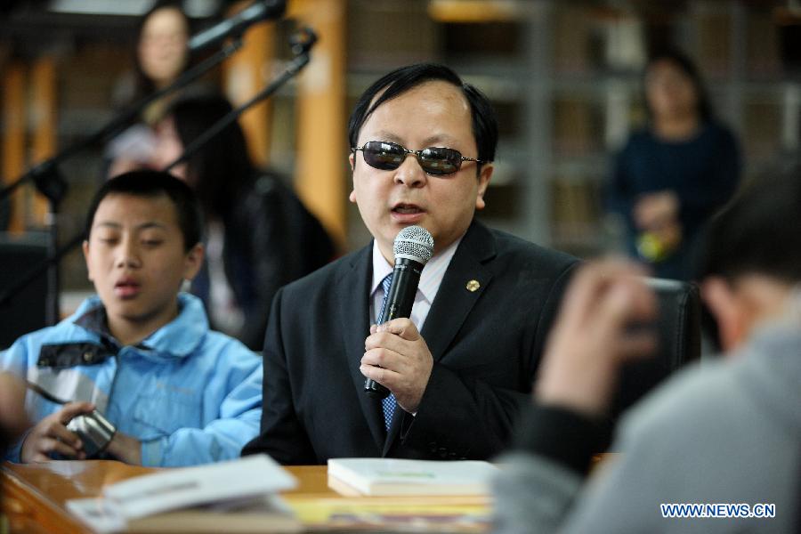 Li Yanyan (2nd L) talks with the visually impaired children during a reading party in the China Braille Library in Beijing, capital of China, April 21, 2013. A reading party for the visually impaired children was held here on Sunday. Li Yanyan, a visually-challenged physician who achieved a medical doctor degree at Palmer West College of Chiropractic in California, the U.S., participated in the reading party with his autobiography and shared his learning experience with the young readers and their parents. (Xinhua/Xu Zijian)