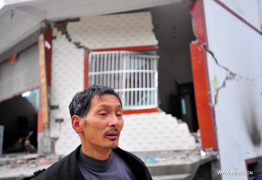 Villager Li Wenquan, 50, stands in front of his house damaged due to the earthquake in Yuxi Village, Baosheng Township, Lushan County, southwest China's Sichuan Province, April 21, 2013. Baosheng Township is another seriously affected area in Lushan. Search and rescue work continued here Sunday, and the work for restoring roads and communications are conducted in the pipelines. (Xinhua/Xiao Yijiu)