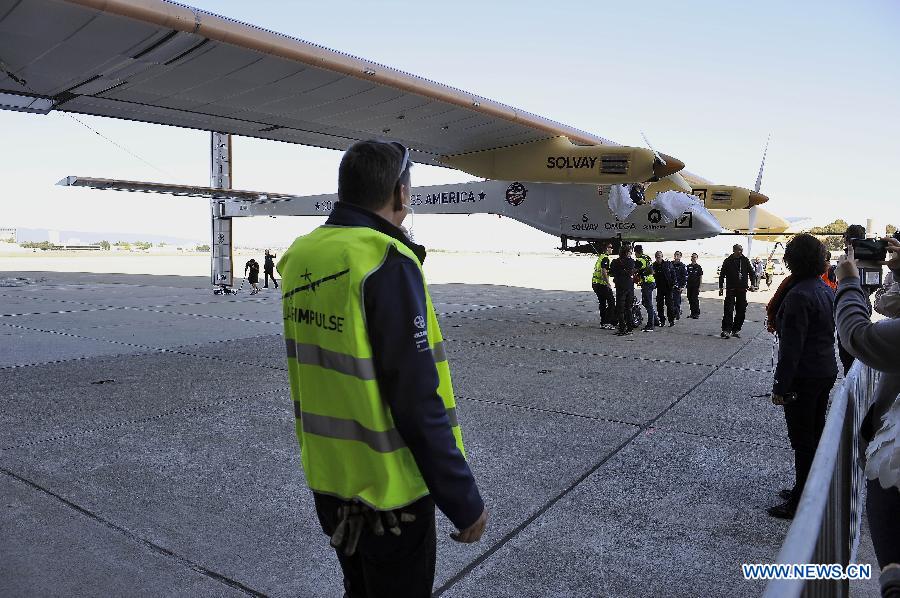 Working staff prepare to push "Solar Impulse" indoor at the Moffett Federal Airfield, Mountain View, California, April 20, 2013. The Swiss-made world's biggest solar-powered aircraft that doesn't use a single drop of fuel will begin traveling across the United States in early May. It'll take off on May 1 from the San Francisco Bay area and reach New York's JFK airport, the final destination, in early July. (Xinhua/Chen Gang) 