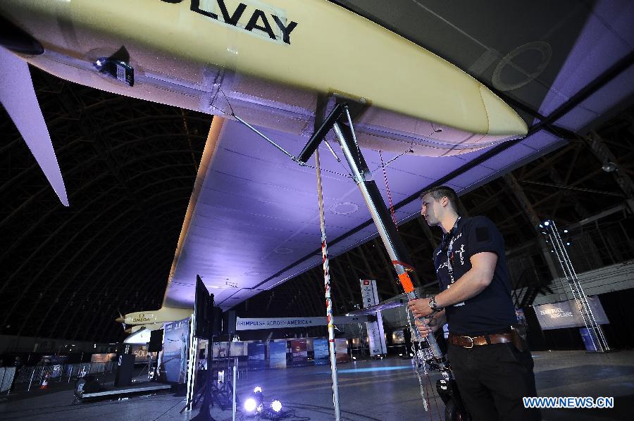 A mechanical worker supports the engine of "Solar Impulse" at the Moffett Federal Airfield, Mountain View, California, April 20, 2013. The Swiss-made world's biggest solar-powered aircraft that doesn't use a single drop of fuel will begin traveling across the United States in early May. It'll take off on May 1 from the San Francisco Bay area and reach New York's JFK airport, the final destination, in early July. (Xinhua/Chen Gang) 