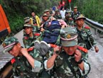 Soldiers carry an injured villager in quake area 