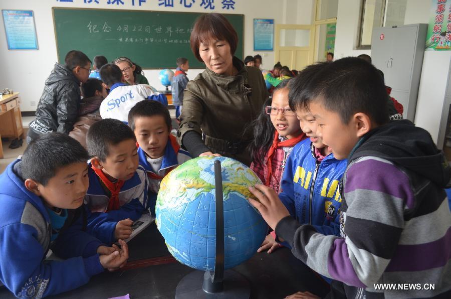 Pupils locate countries on a tellurion during an environment protection activity in Yumen, northwest China's Gansu Province, April 22, 2013. The environment protection activity was held to mark the World Earth Day, which falls on April 22 each year.(Xinhua/Wan Zongping) 