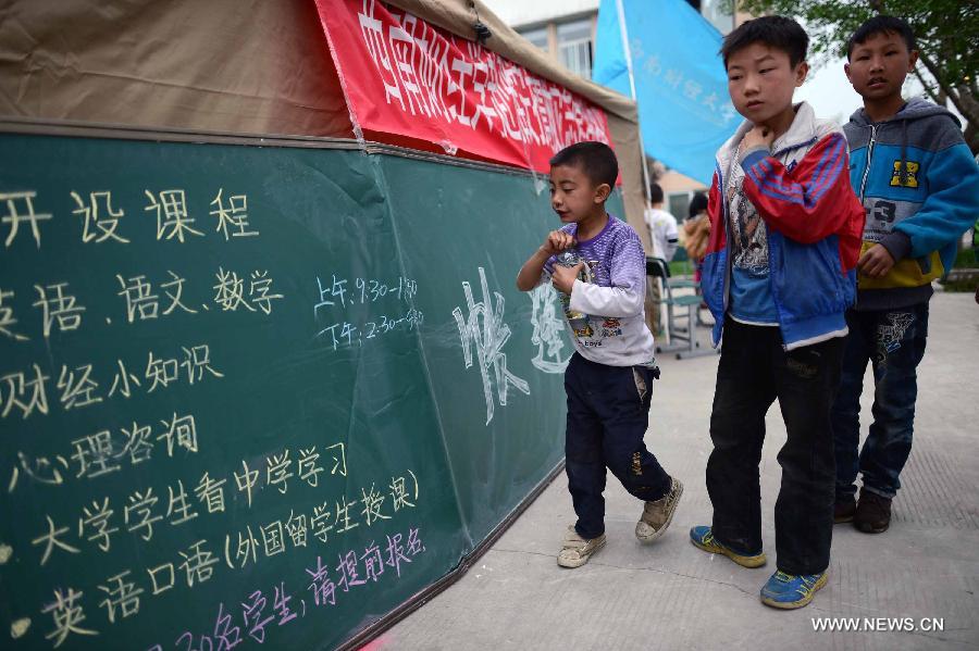 Students check lesson schedules at a temporary school set up at the Lushan Middle School in Lushan County, southwest China's Sichuan Province, April 22, 2013. A temporary school was set up here Monday by 17 volunteers from Southwestern University of Finance and Economics. A 7.0-magnitude earthquake jolted Lushan County of Ya'an City in the morning on April 20. (Xinhua/Jiang Hongjing)