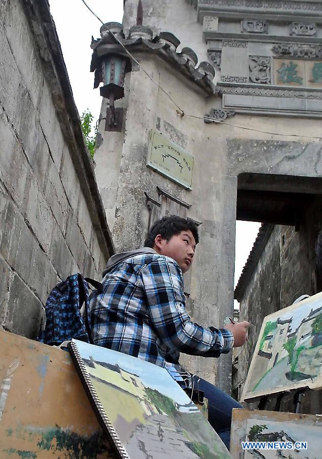 A student draws pictures in Hongcun Village, a famous tourist site in east China's Anhui Province, April 22, 2013. Hongcun, one of the UNESCO World Heritage Sites, took on beautiful spring view and attracted lots of art students. (Xinhua/Wang Song)