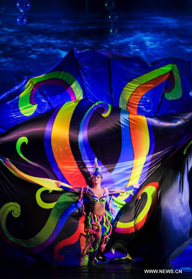 An artist of the Jilin Provincial Performing Troupe performs during a stage show at the Oriental Theatre in Changchun, capital of northeast China's Jilin Province, April 22, 2013. The show, with various art forms including singing, dancing, acrobatics and conjuring, displays folk customs in the Changbai Mountain area. (Xinhua/Xu Chang) 