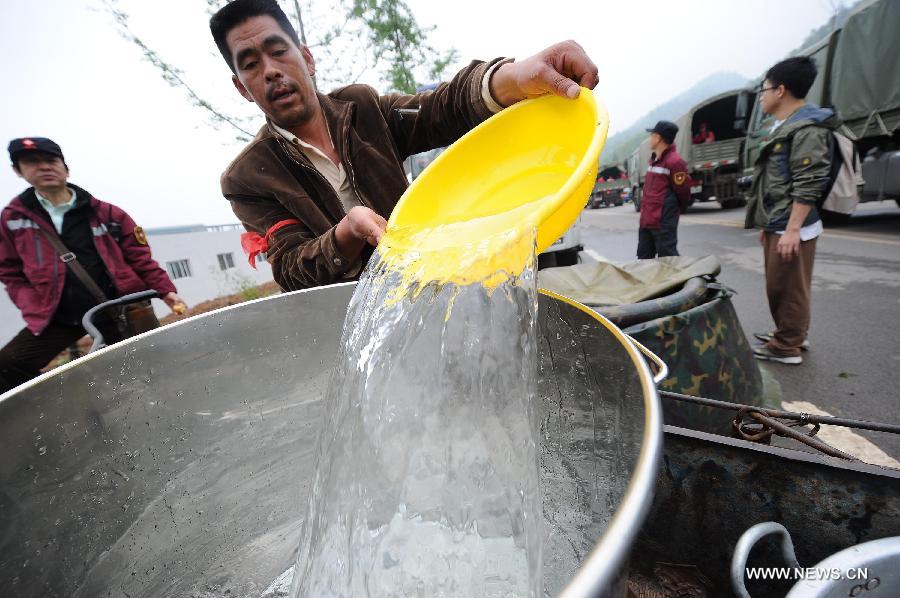 A man takes drinking water at a temporary settlement site in the quake-hit Lushan County, southwest China's Sichuan Province, April 22, 2013. The water and power supply were suspended after a 7.0-magnitude earthquake jolted Lushan County on April 20 morning. Rescue organizations are using water purification equipment to provide drinking water for affected local residents. (Xinhua/Li Jian)