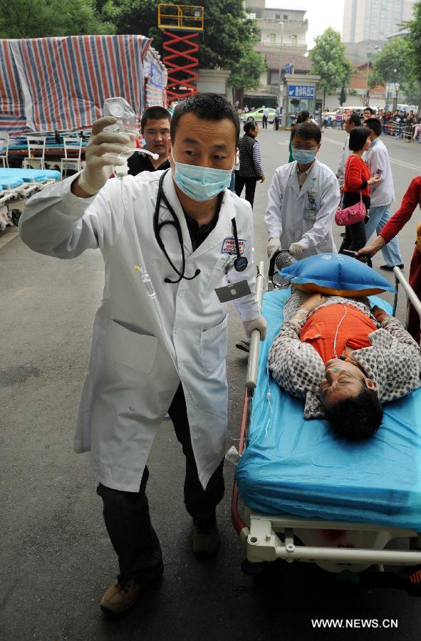 Medical staff carry a quake victim into the Huaxi Hospital of Sichuan University in Chengdu, capital of southwest China's Sichuan Province, April 22, 2013. The hospital opened a green channel for victims after a 7.0-magnitude earthquake jolted Lushan County of Ya'an City in Sichuan on April 20 morning. As of 12 a.m. on April 22, the hospital has received 229 injured people. (Xinhua/Li Ziheng)