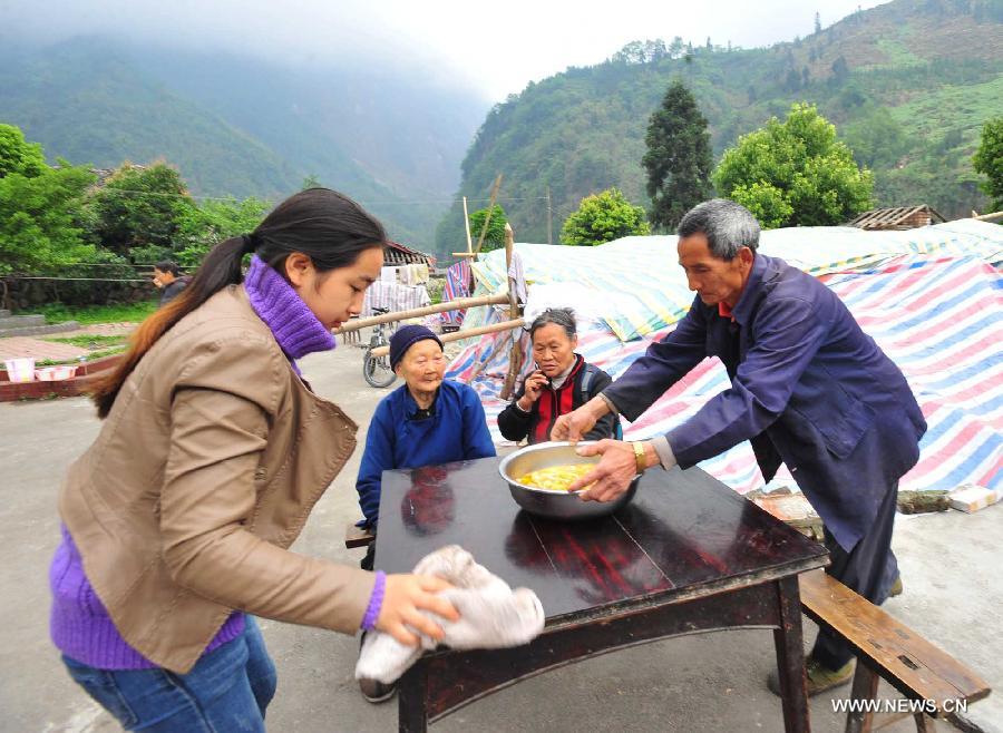 Villagers prepare for their lunch in Yuxi Primary School served as an evacuation settlement in the quake-hit Yuxi Village, Baosheng Township, Lushan County in southwest China's Sichuan Province, April 22, 2013. Over 40 displaced villagers lived in makeshift tents in the settlement where they helped each other to overcome difficulties together. (Xinhua/Xiao Yijiu)