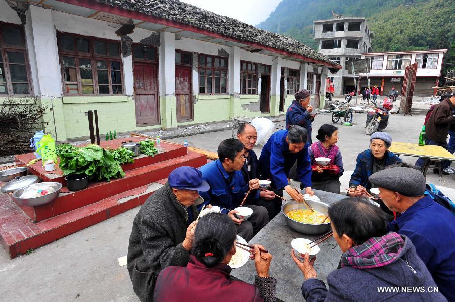 Villagers have lunch in Yuxi Primary School served as an evacuation settlement in the quake-hit Yuxi Village, Baosheng Township, Lushan County in southwest China's Sichuan Province, April 22, 2013. Over 40 displaced villagers lived in makeshift tents in the settlement where they helped each other to overcome difficulties together. (Xinhua/Xiao Yijiu)