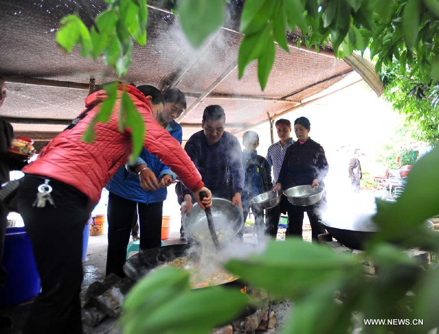 Villagers prepare for their lunch in Yuxi Primary School served as an evacuation settlement in the quake-hit Yuxi Village, Baosheng Township, Lushan County in southwest China's Sichuan Province, April 22, 2013. Over 40 displaced villagers lived in makeshift tents in the settlement where they helped each other to overcome difficulties together. (Xinhua/Xiao Yijiu)