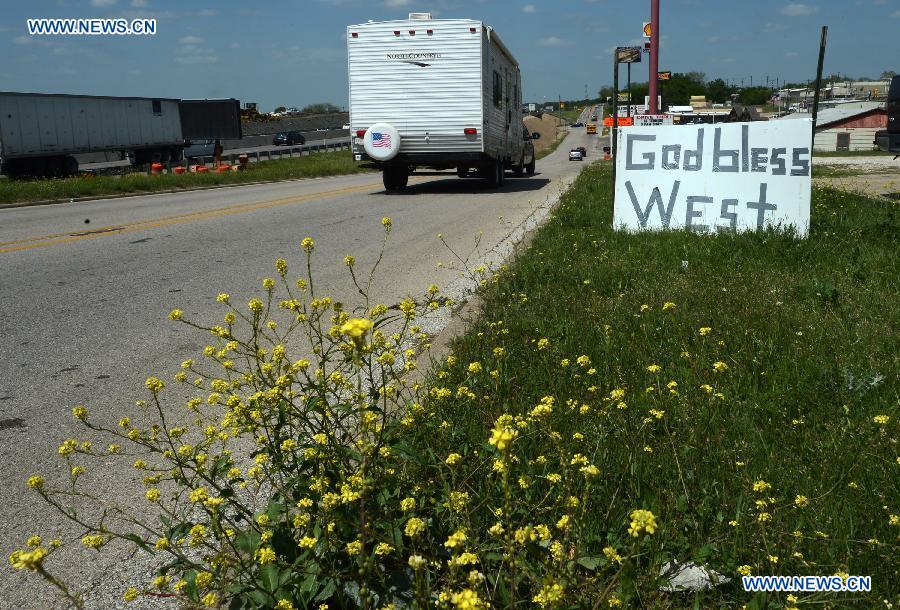 A board with "God bless West" written on is put by a highway to mourn for the victims of the fertilizer plant explosion near West, Texas, the United States, April 22, 2013. (Xinhua/Wang Lei) 