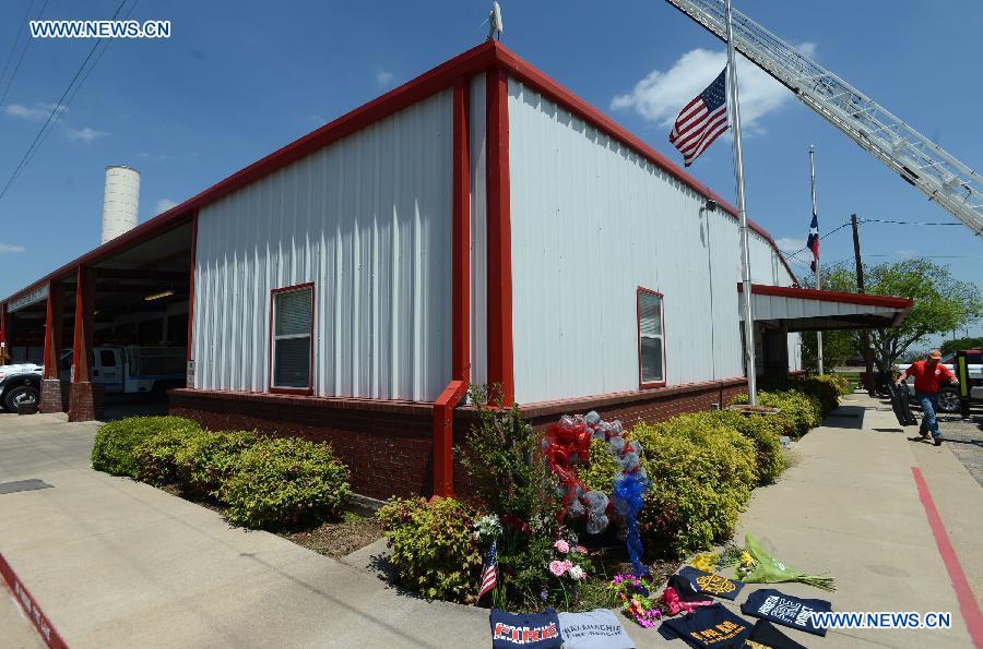 Flowers and clothes of firemen are laid to mourn for the firemen died in the fertilizer plant explosion, outside a fire station in West, Texas, the United States, April 22, 2013. (Xinhua/Wang Lei) 