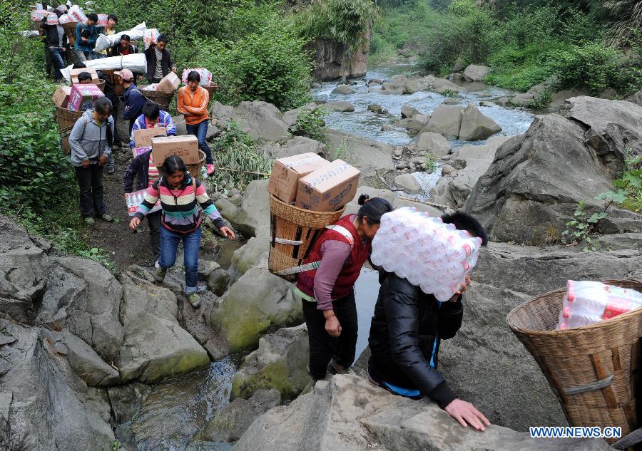 Villagers carrying disaster relief supplies walk in the mountain in quake-hit Shifeng Village of Lushan County, southwest China's Sichuan Province, April 22, 2013. The road linking the Shifeng Village with the outside had been destroyed by a 7.0-magnitude earthquake on April 20. Local villagers set up a 300-member group to climb mountains to get relief supplies outside and then return to the village. Over 40 tonnes of materials had been transported and distributed to over 2,000 villagers. (Xinhua/Li Ziheng)