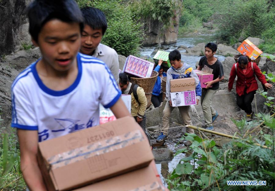 Villagers carrying disaster relief supplies walk in the mountain in quake-hit Shifeng Village of Lushan County, southwest China's Sichuan Province, April 22, 2013. The road linking the Shifeng Village with the outside had been destroyed by a 7.0-magnitude earthquake on April 20. Local villagers set up a 300-member group to climb mountains to get relief supplies outside and then return to the village. Over 40 tonnes of materials had been transported and distributed to over 2,000 villagers. (Xinhua/Li Ziheng)