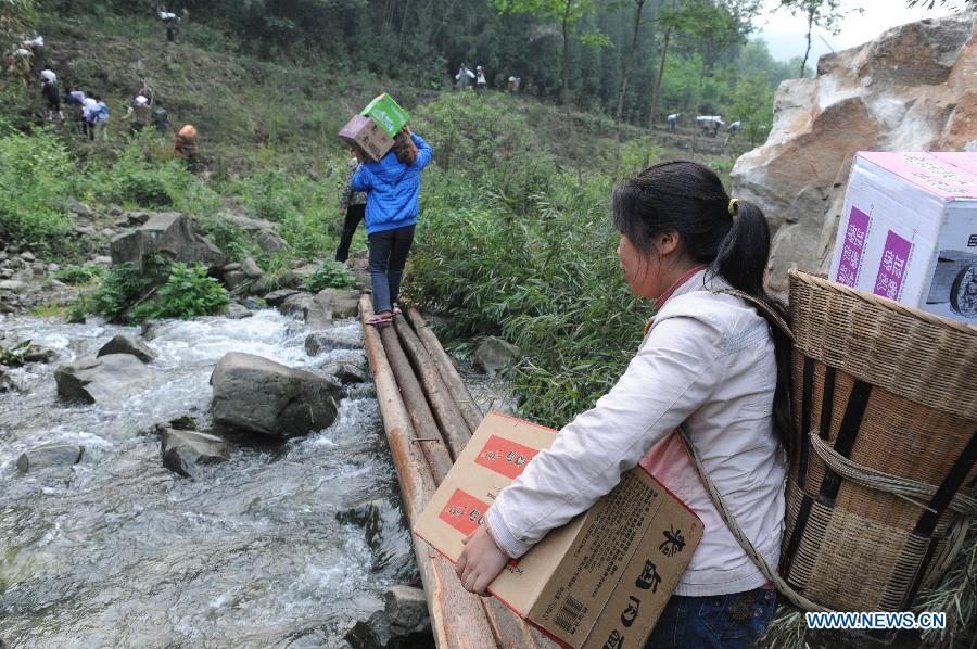 Villagers carrying disaster relief supplies walk in the mountain in quake-hit Shifeng Village of Lushan County, southwest China's Sichuan Province, April 22, 2013. The road linking the Shifeng Village with the outside had been destroyed by a 7.0-magnitude earthquake on April 20. Local villagers set up a 300-member group to climb mountains to get relief supplies outside and then return to the village. Over 40 tonnes of materials had been transported and distributed to over 2,000 villagers. (Xinhua/Li Ziheng)