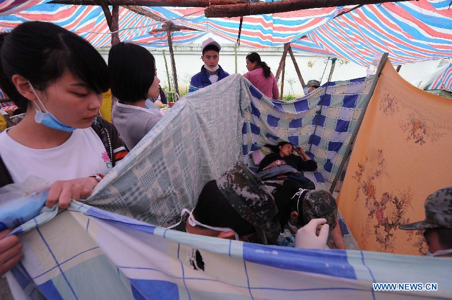 Medical workers take care of Yang Yan, a 20-year-old new mother who has just given birth to a boy, in a tent functioned as temporary hospital in quake-hit Taiping Township of Lushan County, southwest China's Sichuan Province, April 23, 2013. Both mother and baby were fine. Yang and her husband Chen Wei arrived at the hospital in the early morning on Tuesday, after taking a long journey for over three hours from their home in Xingmin Village of the Taiping Township. This was the fourth day after a 7.0-magnitude earthquake jolted Lushan County on April 20. (Xinhua/Li Jian)