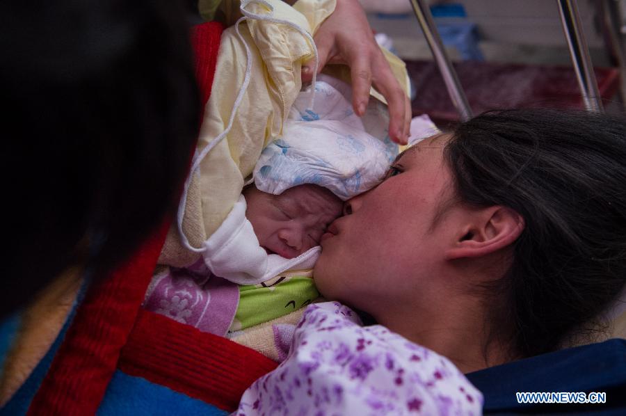 Yang Yan, a 20-year-old new mother, kisses her newborn son in a tent functioned as temporary hospital in quake-hit Taiping Township of Lushan County, southwest China's Sichuan Province, April 23, 2013. Both mother and baby were fine. Yang and her husband Chen Wei arrived at the hospital in the early morning on Tuesday, after taking a long journey for over three hours from their home in Xingmin Village of the Taiping Township. This was the fourth day after a 7.0-magnitude earthquake jolted Lushan County on April 20. (Xinhua/Chen Cheng)