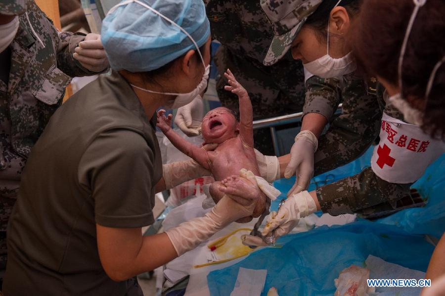 Medical workers take care of a newborn boy in a tent functioned as temporary hospital in quake-hit Taiping Township of Lushan County, southwest China's Sichuan Province, April 23, 2013. The newborn baby was named Chen Qirui, and both mother and baby were fine. The boy's mother Yang Yan, a 20-year-old woman, and father Chen Wei arrived at the hospital in the early morning on Tuesday, after taking a long journey for over three hours from their home in Xingmin Village of the Taiping Township. This was the fourth day after a 7.0-magnitude earthquake jolted Lushan County on April 20. (Xinhua/Chen Cheng)