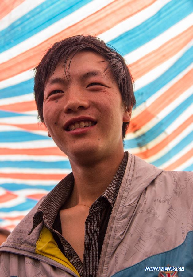 Chen Wei, a new father, smiles after his wife Yang Yan gave birth to a boy in a tent functioned as temporary hospital in quake-hit Taiping Township of Lushan County, southwest China's Sichuan Province, April 23, 2013. Both mother and baby were fine. Yang, 20, and her husband Chen arrived at the hospital in the early morning on Tuesday, after taking a long journey for over three hours from their home in Xingmin Village of the Taiping Township. This was the fourth day after a 7.0-magnitude earthquake jolted Lushan County on April 20. (Xinhua/Chen Cheng)