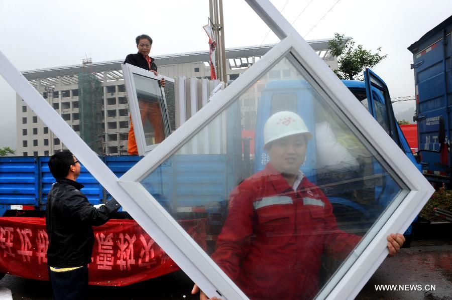 Workers unload building materials to prepare the construction of temporary housing in quake-hit Lushan County, southwest China's Sichuan Province, April 23, 2013. A 7.0-magnitude earthquake jolted Lushan County on April 20. (Xinhua/Li Ziheng) 